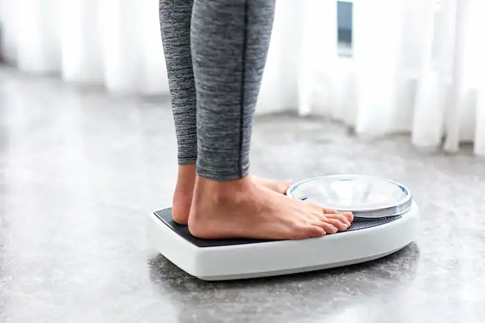woman weighing herself scale