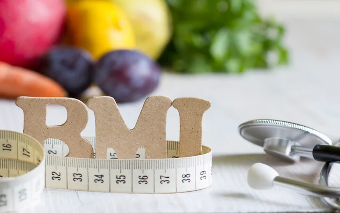 metric tape wrapped around the letters "BMI"