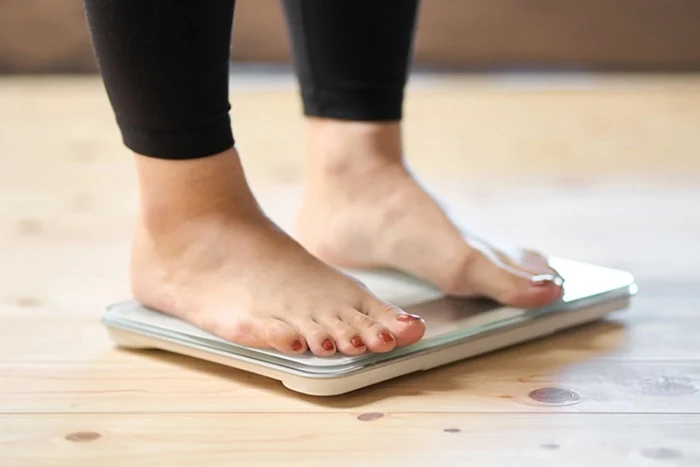 woman stepping on scale