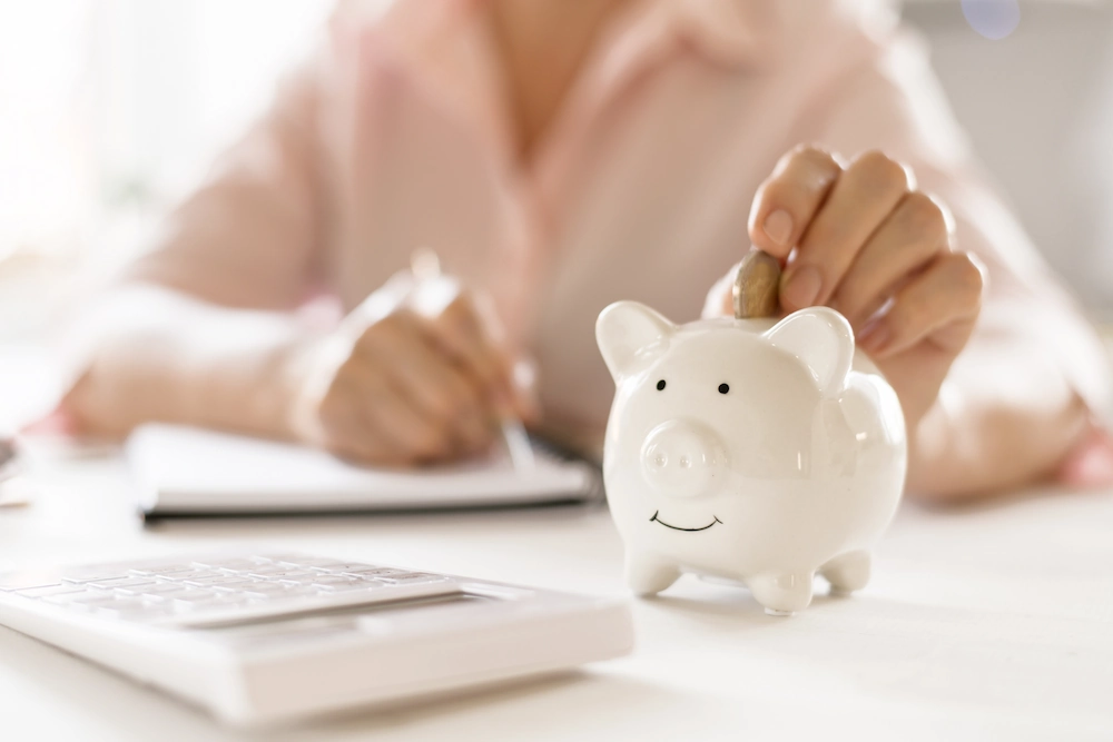dropping money into piggy bank