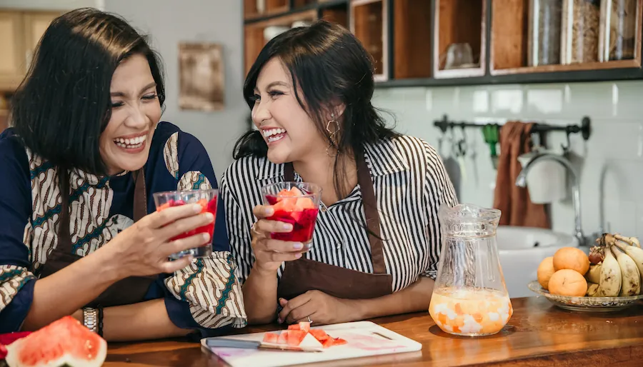 friends in the kitchen making drinks and laughing