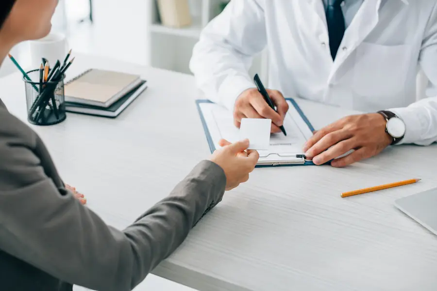 woman at doctors office trying to use insurance card